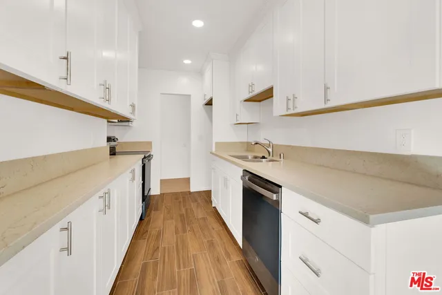 a kitchen with a sink and wooden floor