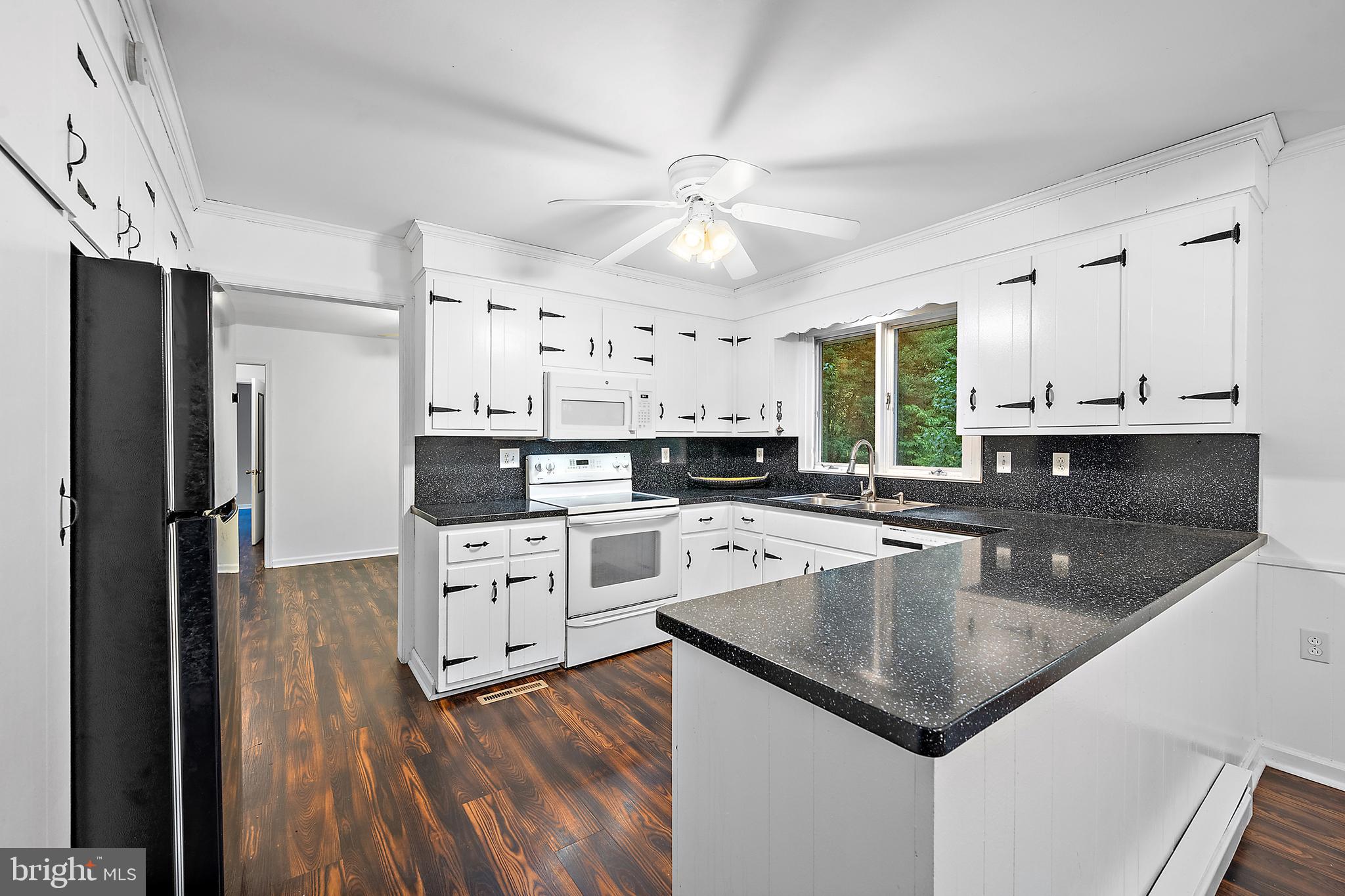 6181 Rockawalkin Road Salisbury, MD 21801 - Photo 16 of 65 a kitchen with granite countertop stainless steel appliances a center island cabinets and a refrigerator