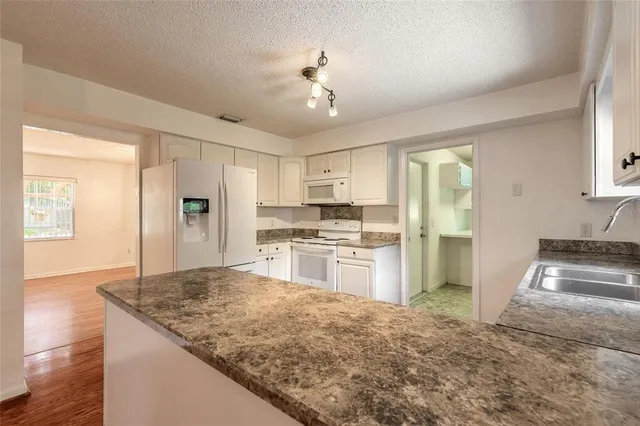 a kitchen with stainless steel appliances granite countertop a stove a refrigerator and a sink