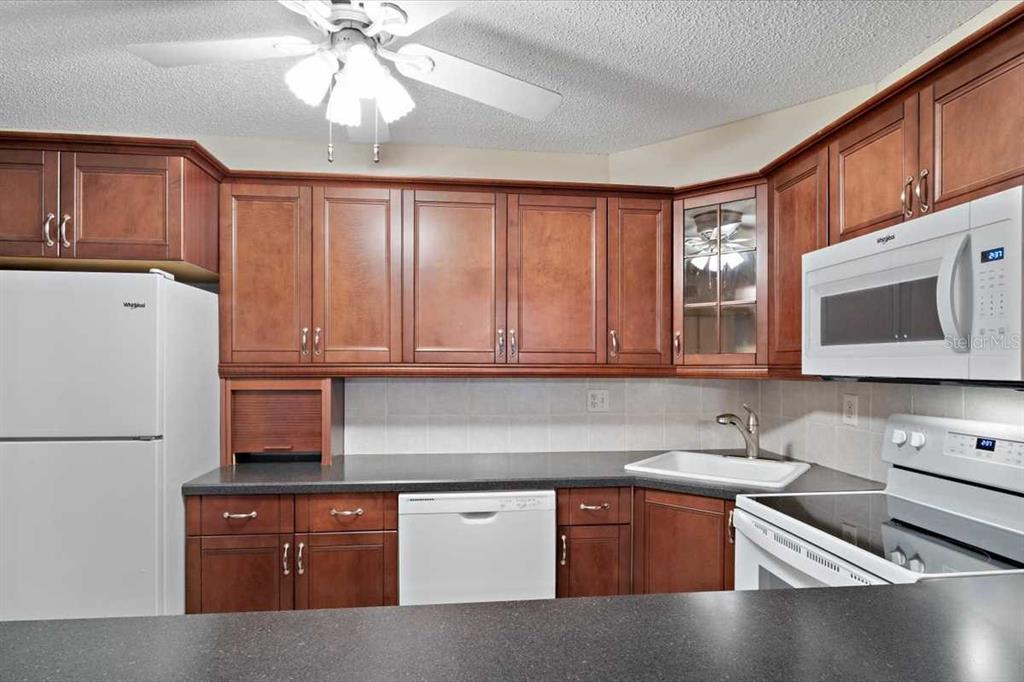 1127 Pine Ridge Circle West, Unit A2 Tarpon Springs, FL 34688 - Photo 5 of 18 a kitchen with stainless steel appliances granite countertop a stove a sink and a refrigerator