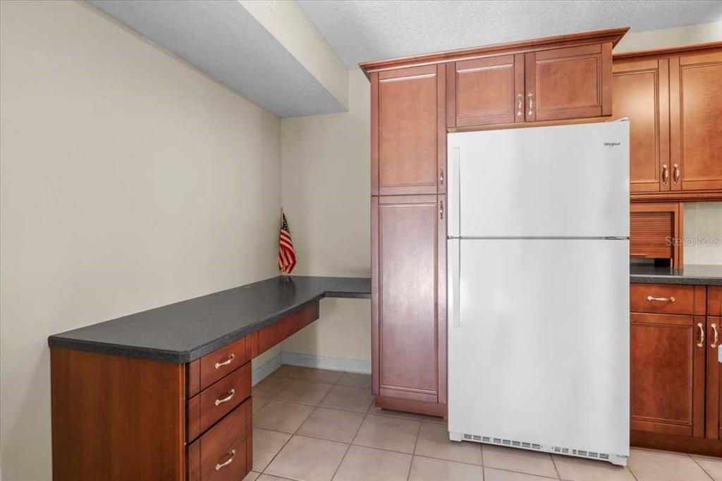 1127 Pine Ridge Circle West, Unit A2 Tarpon Springs, FL 34688 - Photo 7 of 18 a kitchen with a refrigerator and a refrigerator