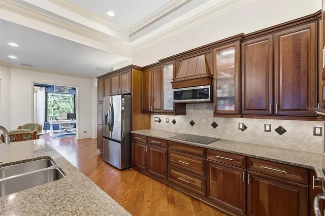 a kitchen with stainless steel appliances granite countertop a refrigerator stove and sink