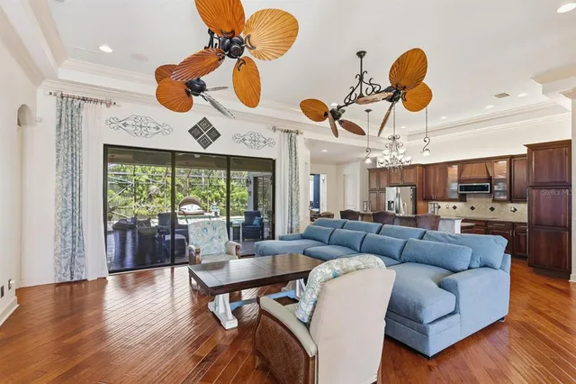 a living room with furniture kitchen view and a large window