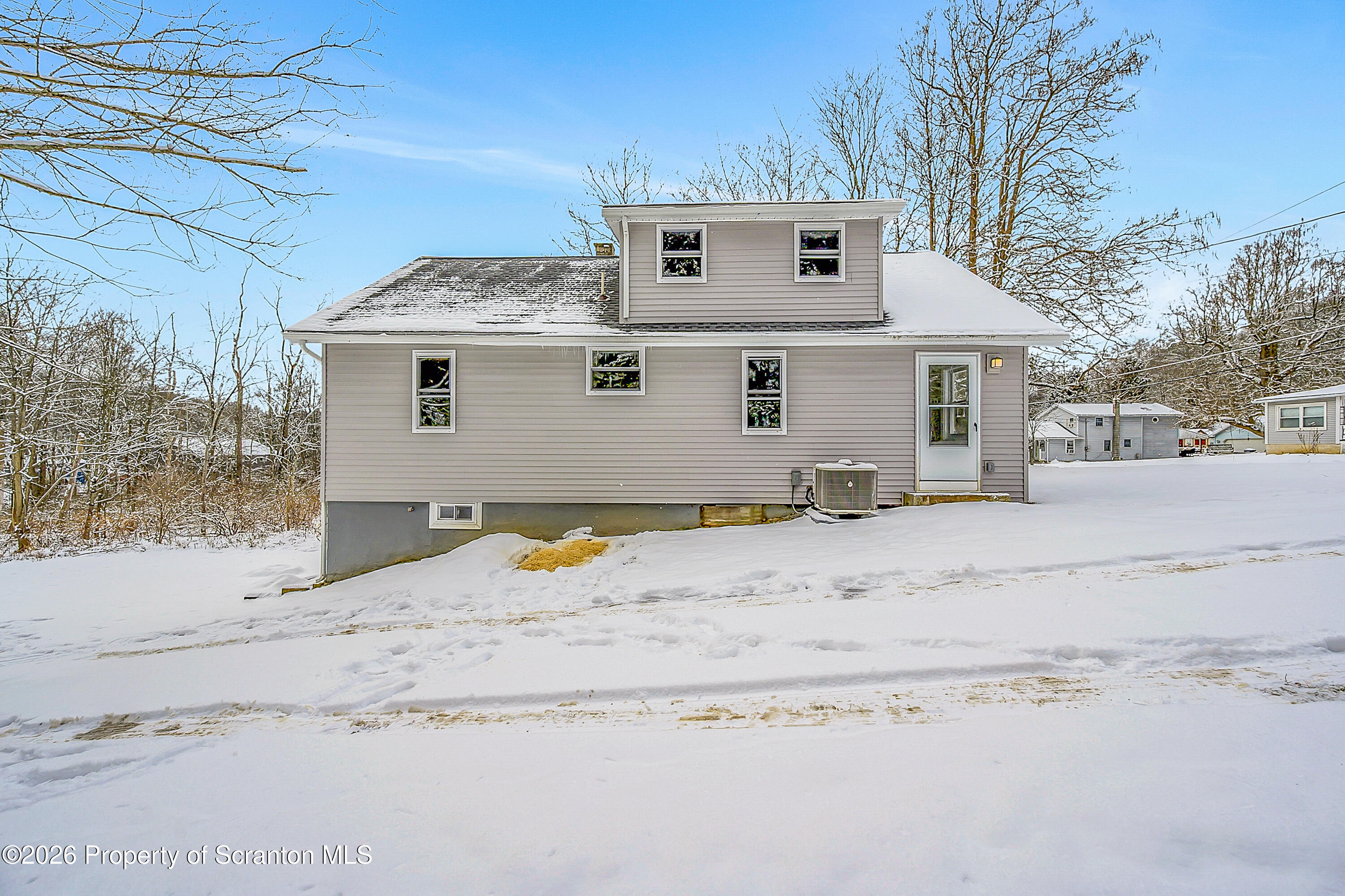 a view of a house with snow on the road