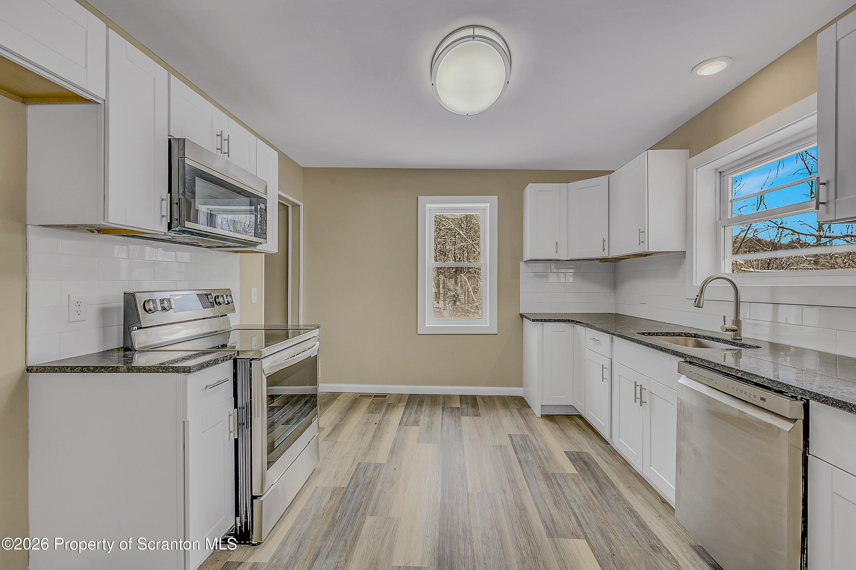 642 Bodle Road Wyoming, PA 18644 - Photo 15 of 33 a kitchen with stainless steel appliances a stove a sink cabinets and wooden floor
