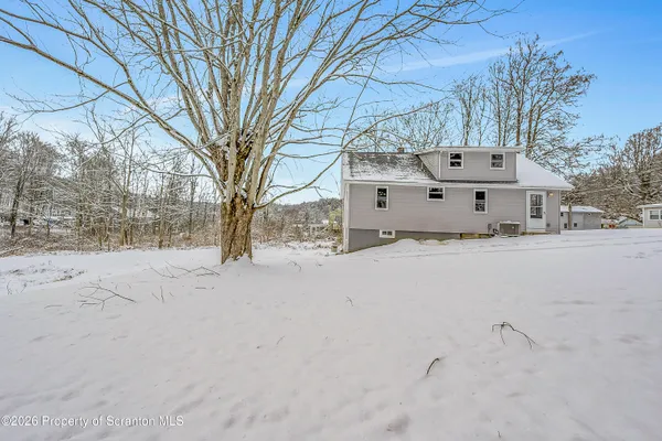 a front view of house with a yard covered in snow
