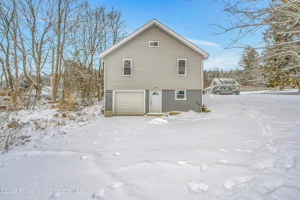 a view of a house with a yard covered in snow
