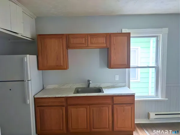 a kitchen with stainless steel appliances granite countertop a sink cabinets and a refrigerator