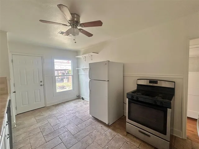 a kitchen with a refrigerator and a stove top oven