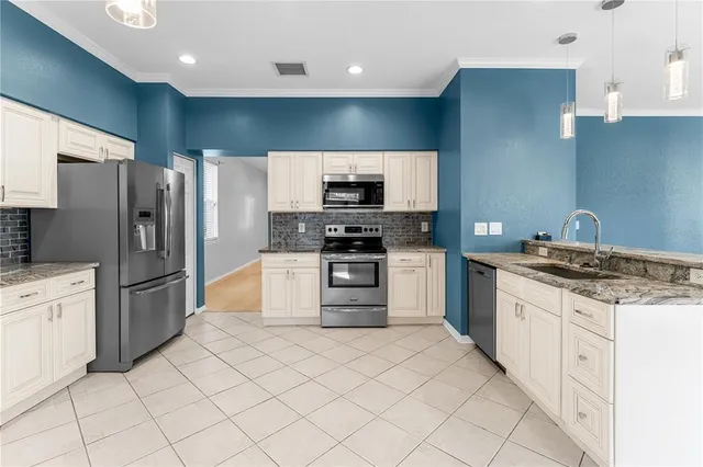 a kitchen with white cabinets and a window