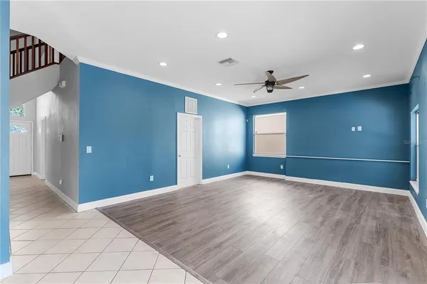 a view of an empty room with a window and kitchen view