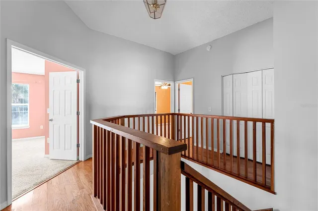 an empty room with windows and ceiling fan