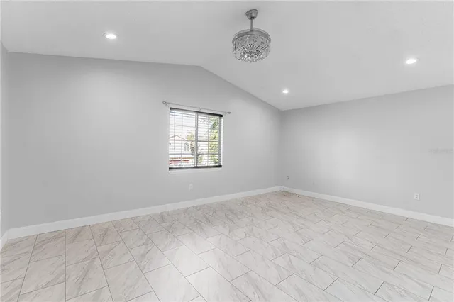 an empty room with windows and ceiling fan