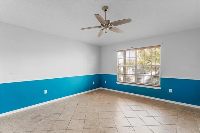 an empty room and chandelier fan