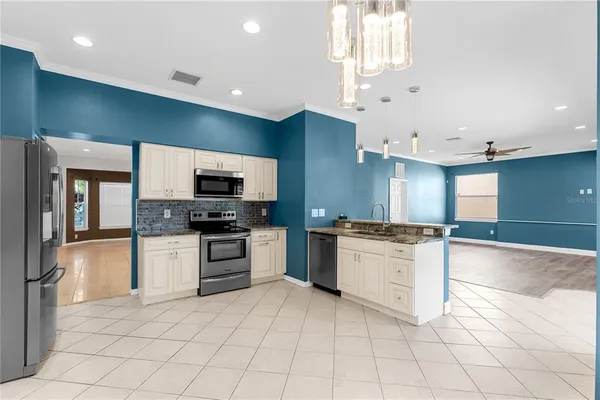 a kitchen with white cabinets and a window