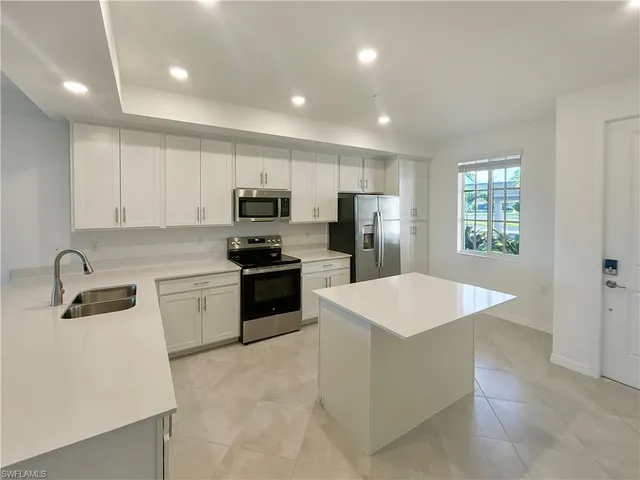 a kitchen with stainless steel appliances a refrigerator sink and stove