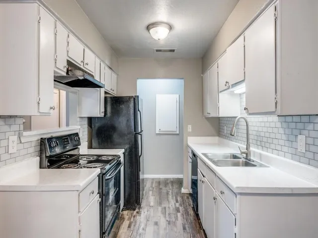 a kitchen that has a sink a stove and a refrigerator