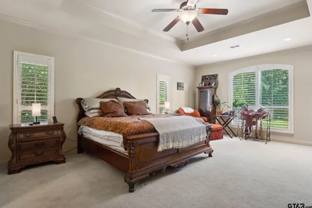 a spacious bedroom with a bed a chandelier and a large window