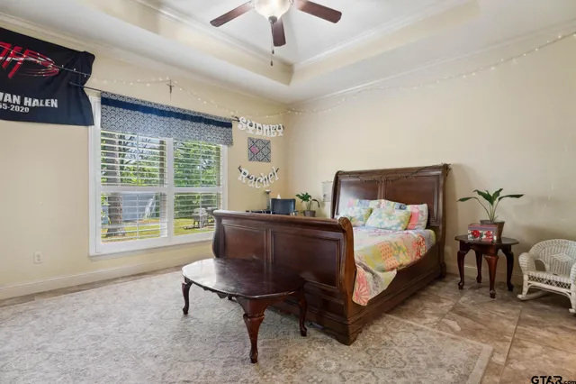 a bed room with a bed chair and a ceiling fan