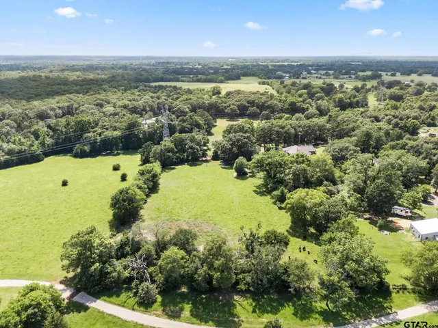 an aerial view of a houses with yard and lake view