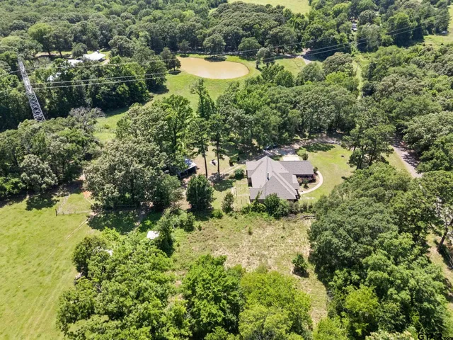 an aerial view of a house with a yard and lake view