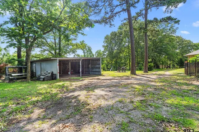 a view of a house with backyard and trees