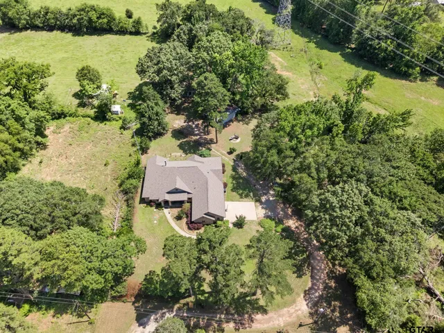 an aerial view of a house with a yard and lake view
