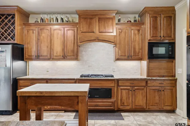 a kitchen with granite countertop a refrigerator and a stove top oven