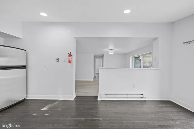 an empty room with wooden floor and cabinet