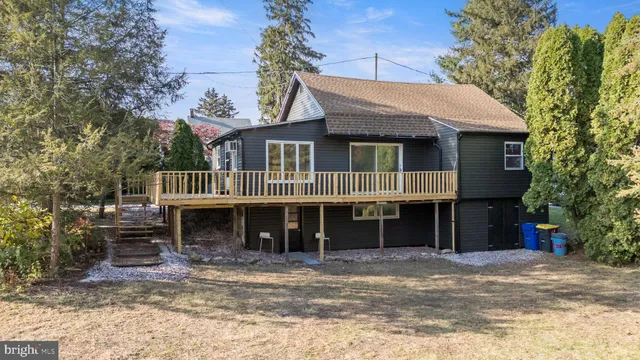 a front view of a house with a yard and glass top table and chairs