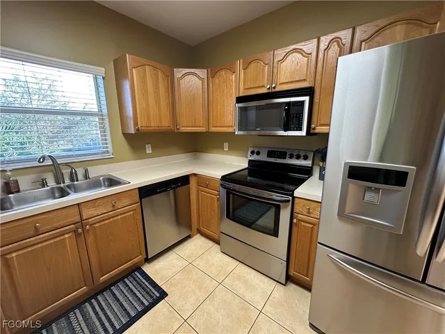 a kitchen with stainless steel appliances a refrigerator sink and microwave