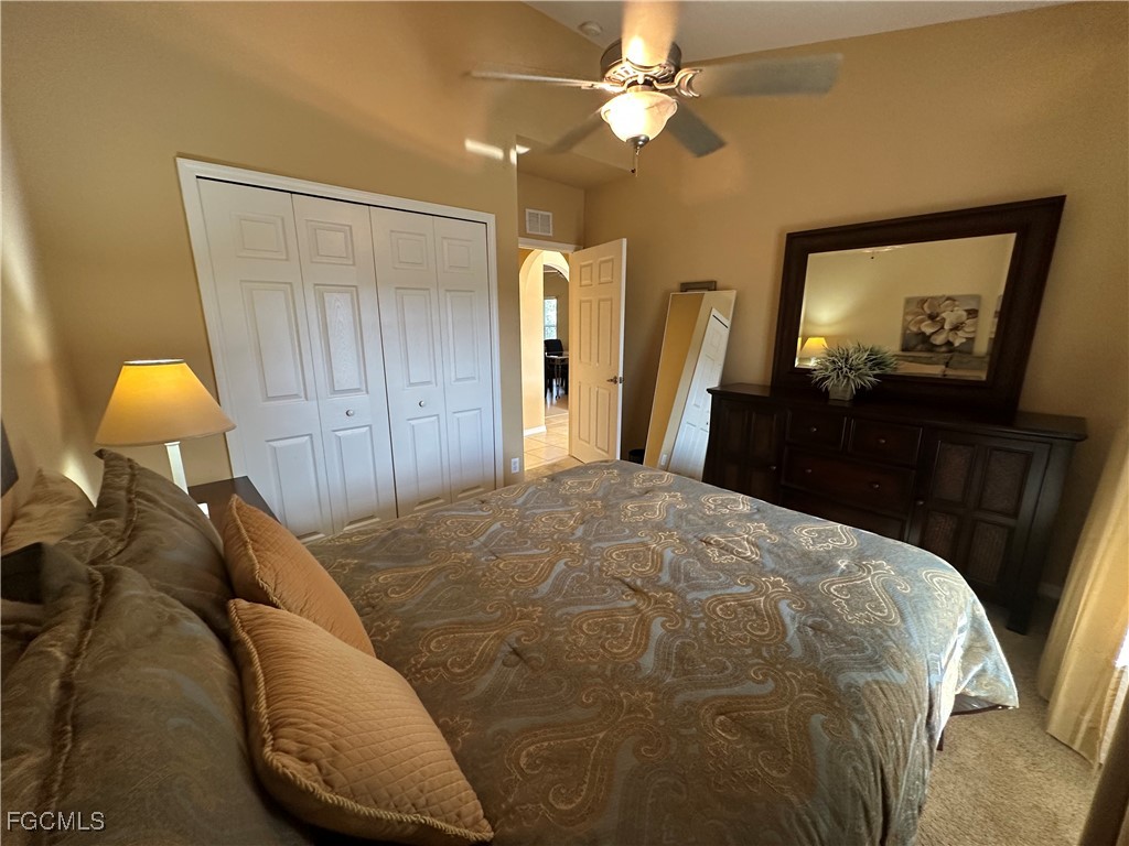 2280 Somerset Ridge Drive, Unit 204 Lehigh Acres, FL 33973 - Photo 15 of 41 a bed room with a bed mirror and a lamp on table