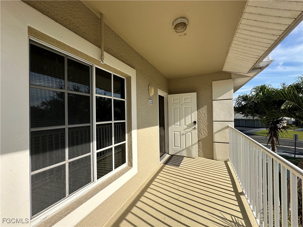 2280 Somerset Ridge Drive, Unit 204 Lehigh Acres, FL 33973 - Photo 3 of 41 a view of a balcony with wooden floor and fence