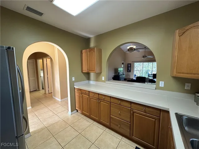 a view of a sink and dishwasher with a large mirror next to a window