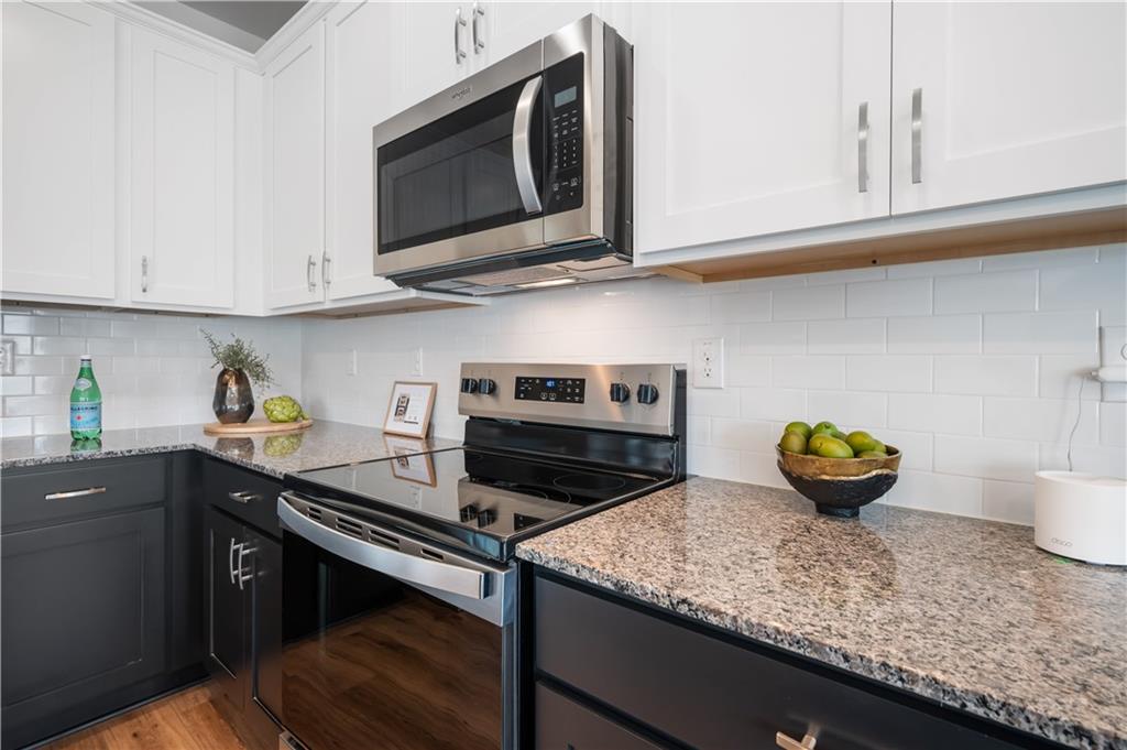 9437 Maple Grove Lane Jonesboro, GA 30238 - Photo 13 of 32 a kitchen with stainless steel appliances granite countertop a sink a stove and cabinets