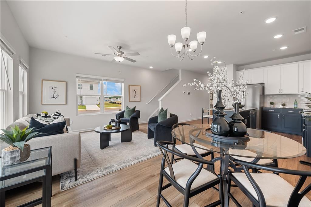 9437 Maple Grove Lane Jonesboro, GA 30238 - Photo 14 of 32 a view of a dining room with furniture a chandelier and wooden floor