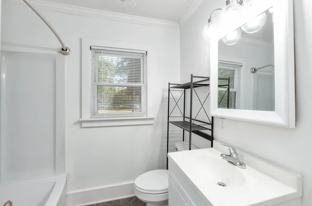 a bathroom with a sink a toilet and a mirror