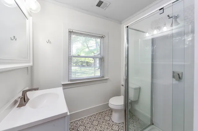 a bathroom with a sink a toilet and shower