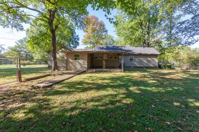 a view of a house with a yard and tree