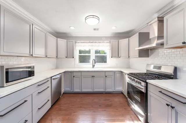 a kitchen with cabinets appliances and a window
