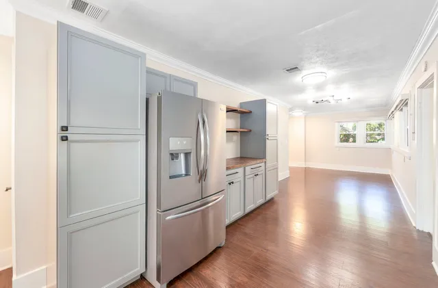 a kitchen with stainless steel appliances a refrigerator and wooden floor