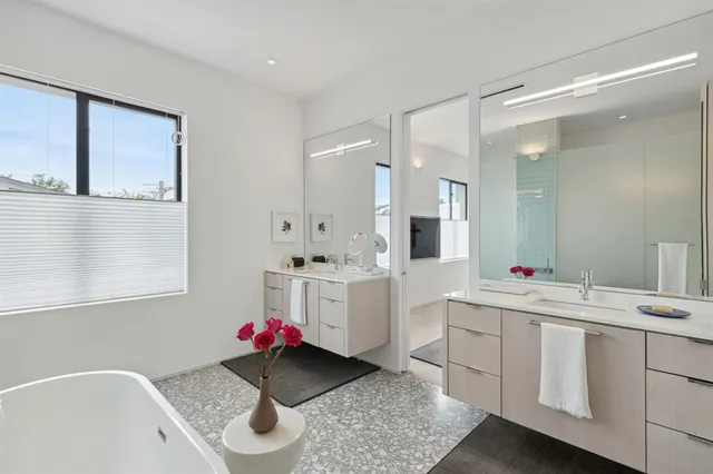 a bathroom with a sink vanity mirror bathtub and toilet