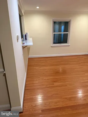 a view of an empty room with wooden floor and stairs