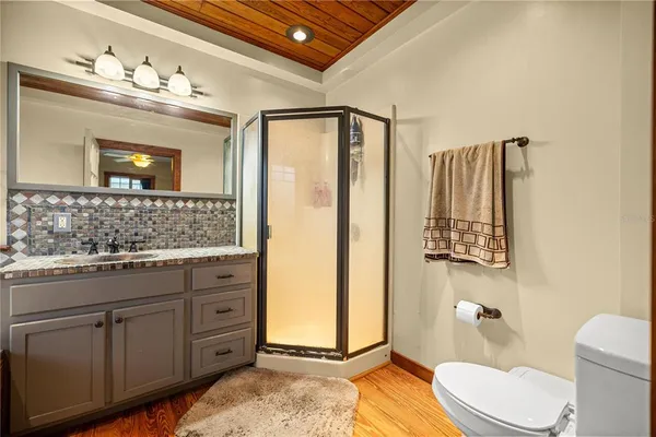 a bathroom with a granite countertop sink toilet and shower