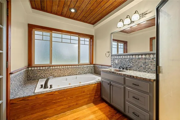 a bathroom with a tub sink and mirror