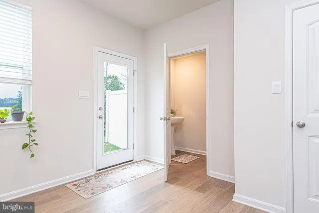 a view of a hallway with wooden floor and a livingroom