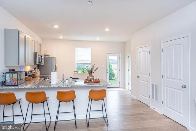 a kitchen with cabinets and chairs