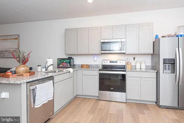 a kitchen with stainless steel appliances granite countertop a stove a sink and a refrigerator