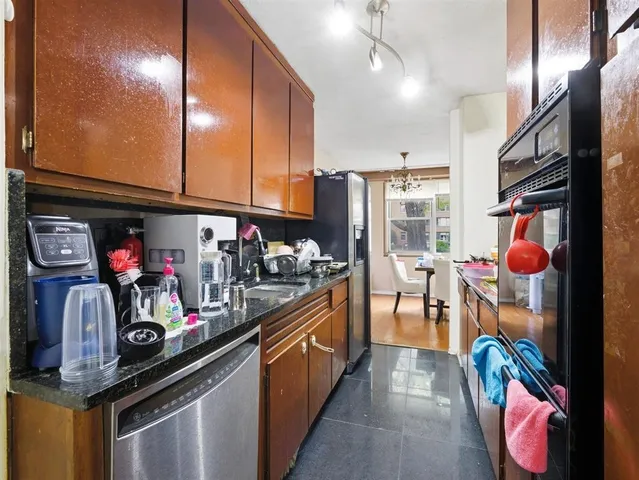 a kitchen filled with stainless steel appliances granite countertop a sink and cabinets