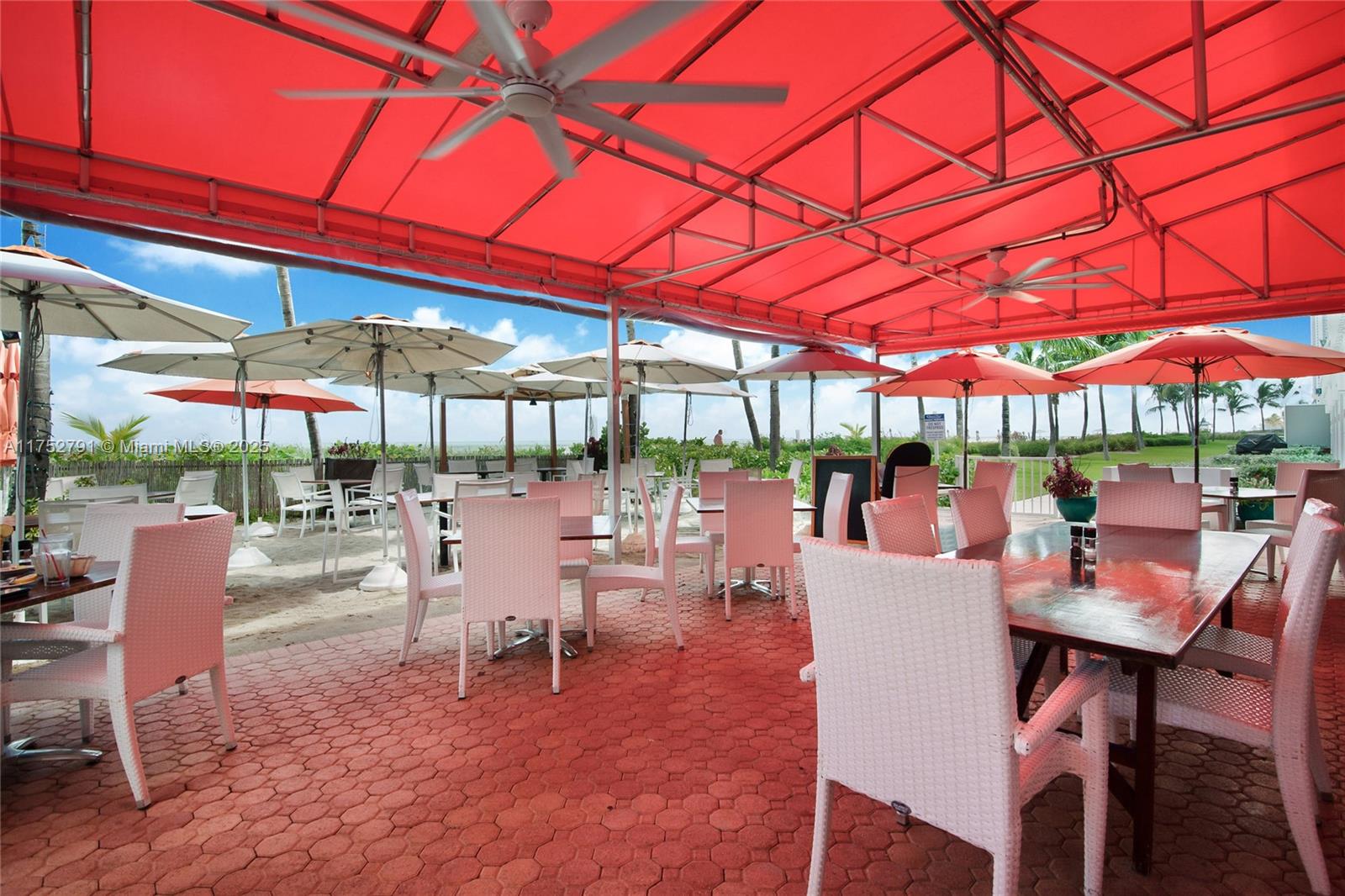 19111 Collins Avenue, Unit PH4 Sunny Isles Beach, FL 33160 - Photo 30 of 73 a view of a patio with a dining table and chairs under an umbrella